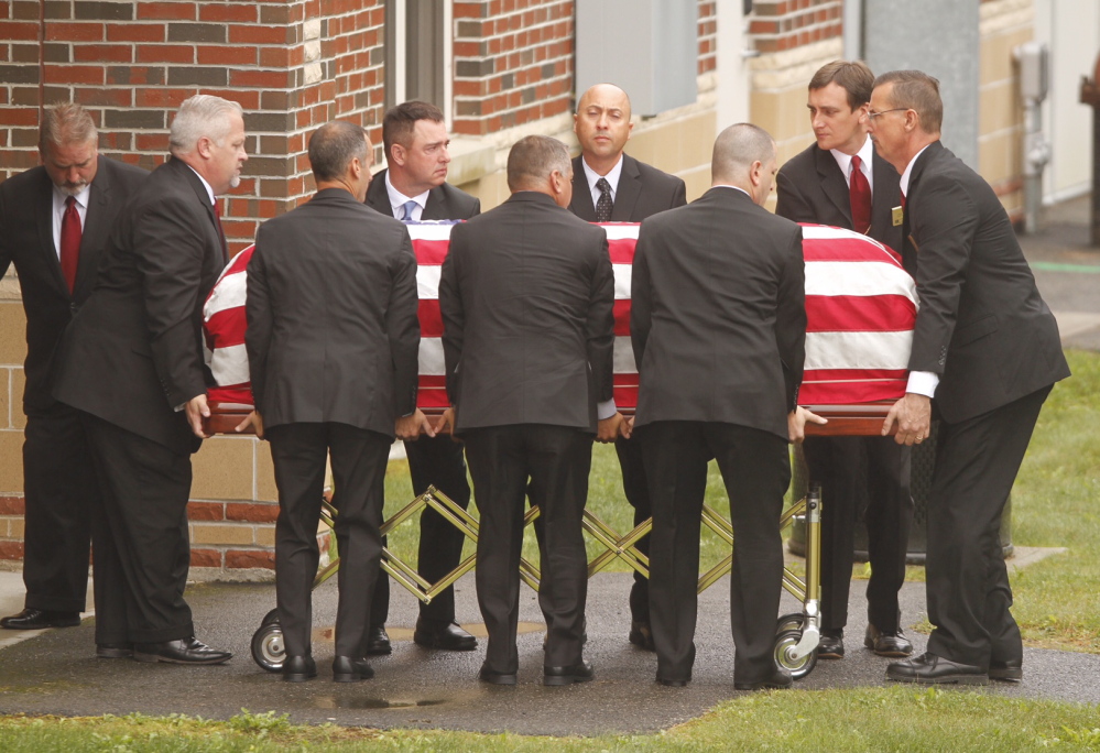 The flag-draped casket of former L.L. Bean leader Leon Gorman is carried by pallbearers from his memorial service at the Westbrook Performing Arts Center on Sunday.