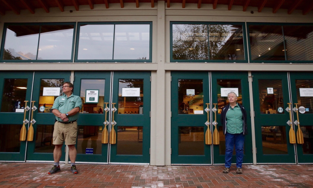 Longtime employees Mark Phillips and Marilyn Lucey stand at the entrance to L.L. Bean’s flagship store in Freeport. The store is closed Sunday from 8 a.m. to noon in memoriam of Leon A. Gorman, who died Sept. 3.