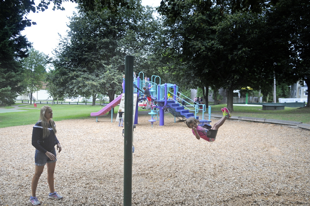 Millie Polizotto, 4, swings after getting a push from Julia Clukey during a rededication of Cunningham Park in Augusta on Sunday. Polizotto is the great-granddaughter of Jack Cunningham, whom the park was named after. Clukey grew up across the street from the park.