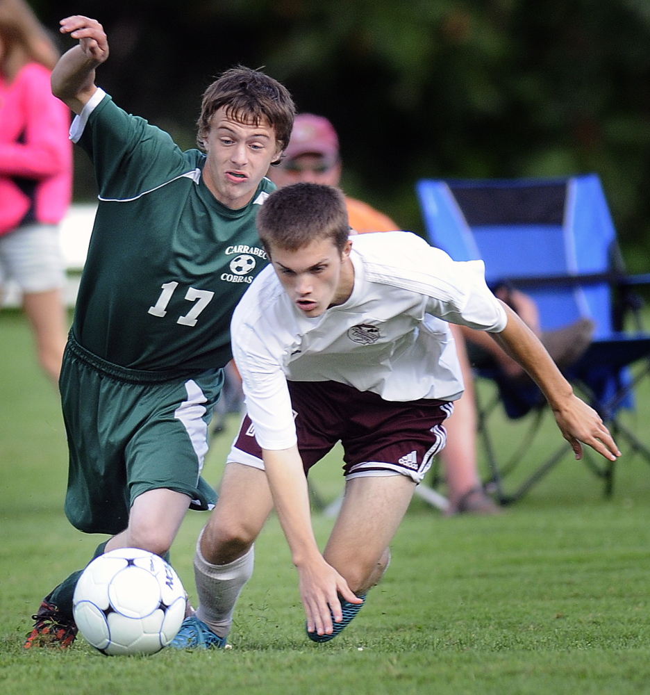 Staff photo by Andy Molloy
Monmouth Academy’s Gage Cote, right, and Carrabec High School’s Jarrod Daigle scramble for the ball during a soccer game Monday in Monmouth.