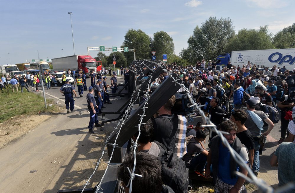 Refugees wait at the closed border station between Serbia and Hungary in Horgos, Serbia, Tuesday.