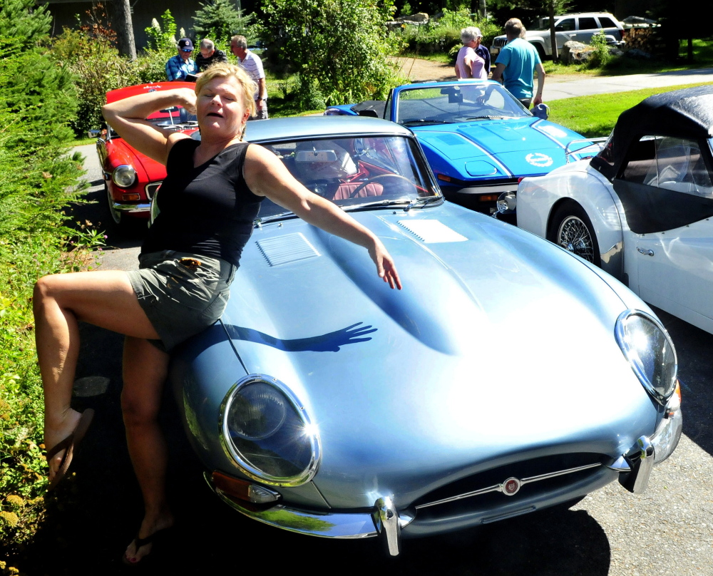 Nona Fuller of Nova Scotia poses with her 1966 Jaguar E-Series sports car at a stop in North Belgrade on Tuesday.  Fuller and others with the BATANS club, British Automobile Touring Association Nova Scotia, were driving their British cars from Nova Scotia to Vermont.