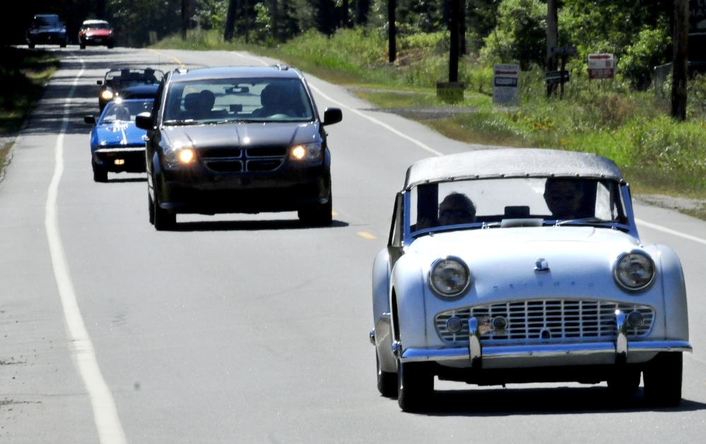 Allan McClure of Winslow drives his 1960 Triumph TR3A as other participants of a British car touring group follow — interrupted by a very non-British Chrysler van — on Route 8 in North Belgrade to resident Steve and Janet Towle’s home on Tuesday. The group was traveling from Nova Scotia to Stowe, Vermont.