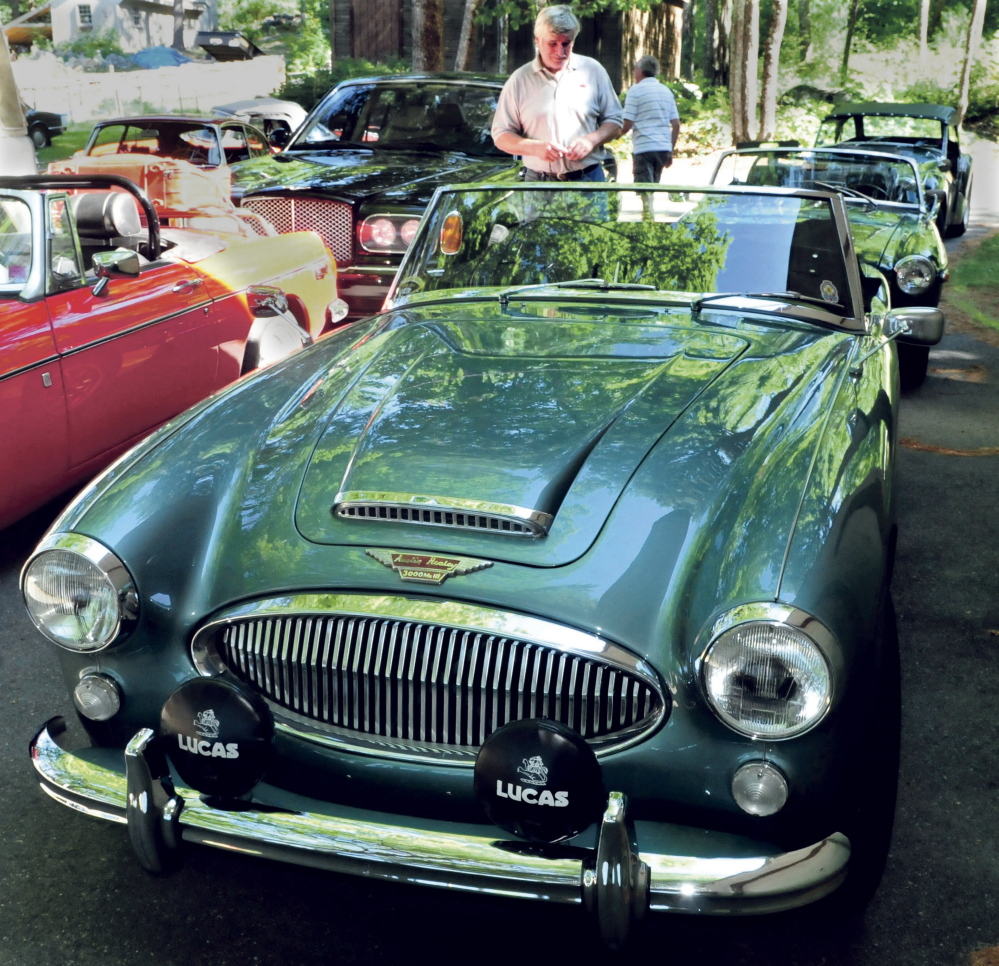 Ray Morrow of Smithfield admires an Austin Healey 3000 at the home of Steve and Janet Towle in North Belgrade on Tuesday. The car was one of a caravan of British-made cars on their way from Nova Scotia to Stowe, Vermont, for the British Invasion car show.