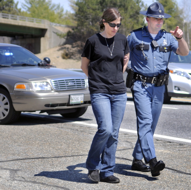 Demitria Buhalis is escorted by Maine State Police Sgt. Patrick Hood to a cruiser while being arrested on Interstate 95 in West Gardiner on April 22. Buhalis pleaded guilty Tuesday to criminal threatening with a dangerous weapon in connection with a road rage incident on that day on Interstate 95 in Sidney.