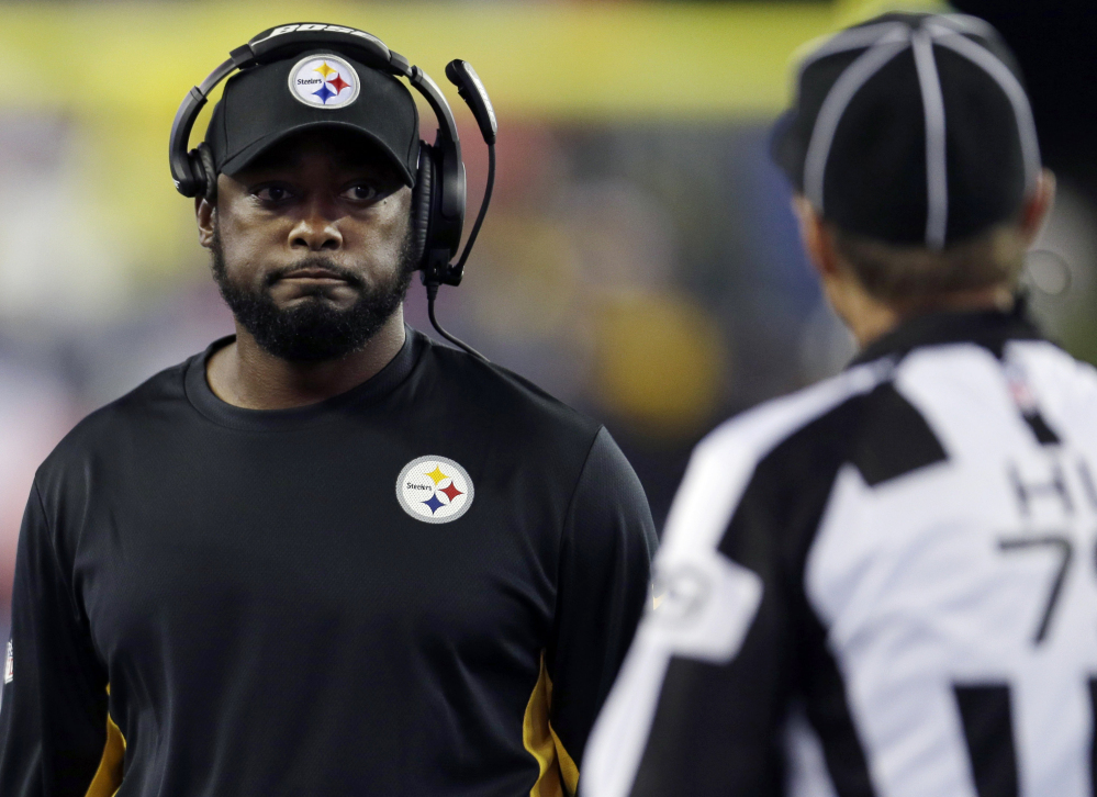 Pittsburgh Steelers head coach Mike Tomlin, center, talks to  head linesman Kent Payne, right, in the first half of a game last week against the New England Patriots in Foxborough, Mass.