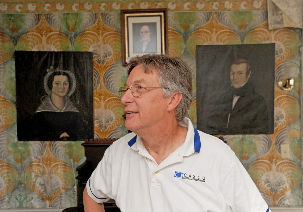 Peter Weston stands in front of pictures of relatives, Deacon Ben Weston, top picture, Nathan Weston, right picture and Almeda Weston, left picture, during a tour of the Weston Homestead in Madison in July 2014. Peter Weston, the 4th generation descendant of Benjamin Weston who built the homestead in the early 1800s, has the piece of history up for sale.