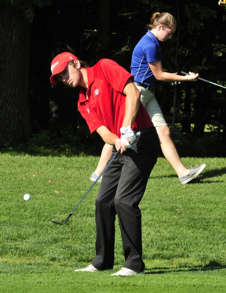 Cony’s Justin Rodrigue chips on the third hole in a match against Lawrence on Wednesday at the Clinton Golf Course. Lawrence’s Michaela Hues is in background. Rodrigue shot a 49 as the Rams defeated the Bulldogs 9-0.