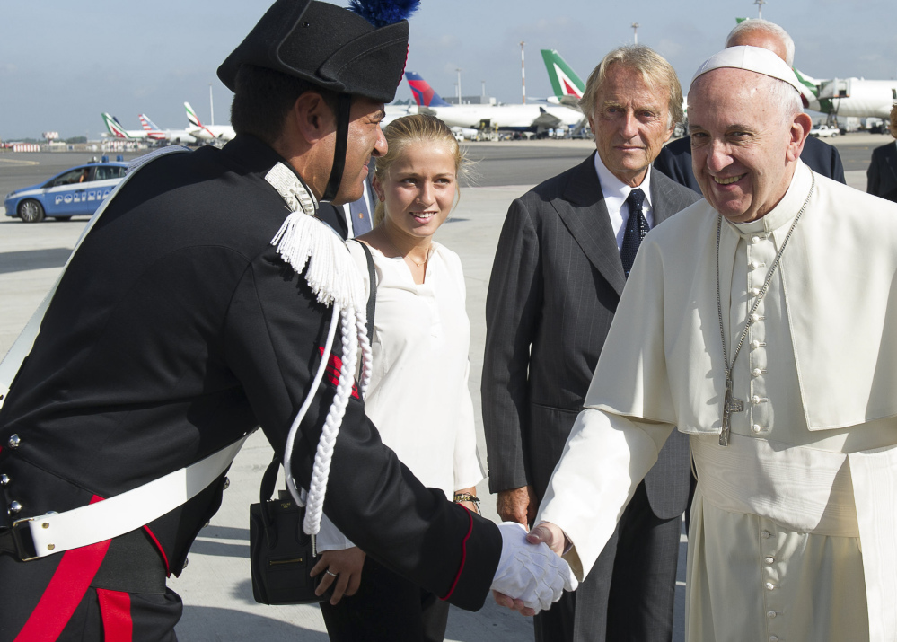 Pope Francis, flanked by Alitalia CEO and chairman Luca Cordero di Montezemolo, second from right, and his daughter, Guia, is greeted by an Italian Carabinieri paramilitary police officer, left, as he arrives to board his flight to Cuba, where he will start a 10-day trip including the United States.