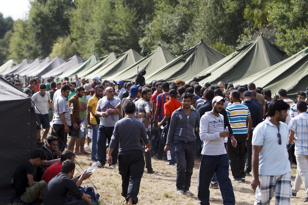 Migrants and refugees walk near tents tents at a collection point set up in Szentgotthard, near the Austrian border on Saturday.