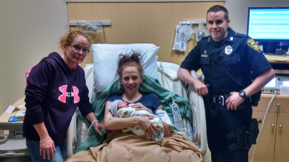 Alice Ingalls, 25, of Vassalboro, holds her new baby girl at MaineGeneral Medical Center alongside her mother, Dawn Lagassie of Vassalboro, and Augusta Police Officer Michael Raymond, who helped deliver the child. Photo courtesy Augusta Police.