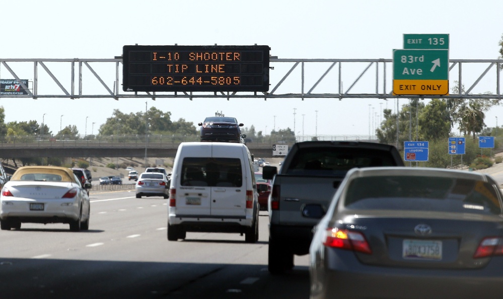 A sign still displays a shooter tip line above Interstate 10, Friday in Phoenix.