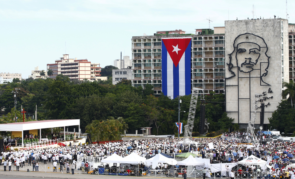 People gather in Revolution Square as Pope Francis celebrates Mass in Havana, Cuba, on Sunday, where a sculpture of revolutionary hero Ernesto “Che” Guevara and a Cuban flag decorate government buildings.