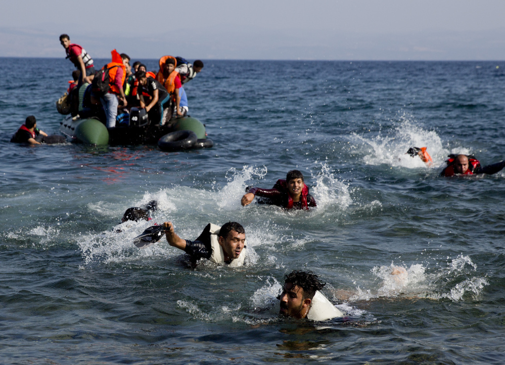 Migrants whose boat stalled at sea while crossing from Turkey to Greece swim toward shore off the island of Lesbos, Greece, on Sunday. A boat with 46 migrants sank off the coast of Greece and 26 people were missing.