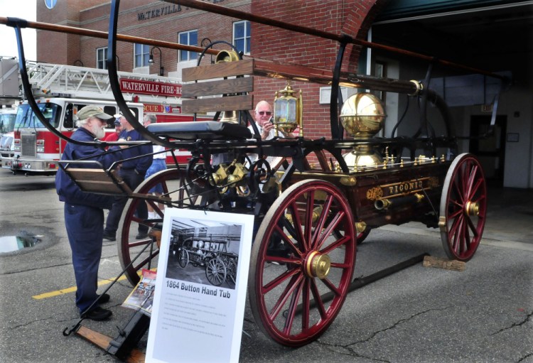 Dale Burnell, left, and David Bolduc look over an 1800s’ horse-drawn hand pumper during an open house at Waterville Fire Department Central Station on Sunday.