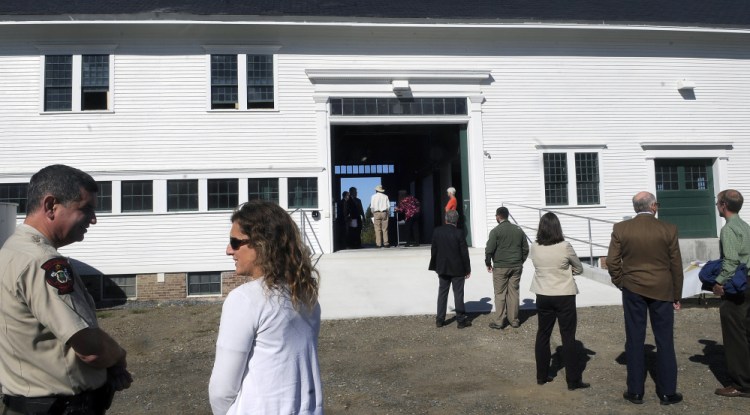 State officials gather Monday outside of the Campbell Barn in Augusta during a dedication ceremony for the renovated structure at the state complex on the city’s east side.