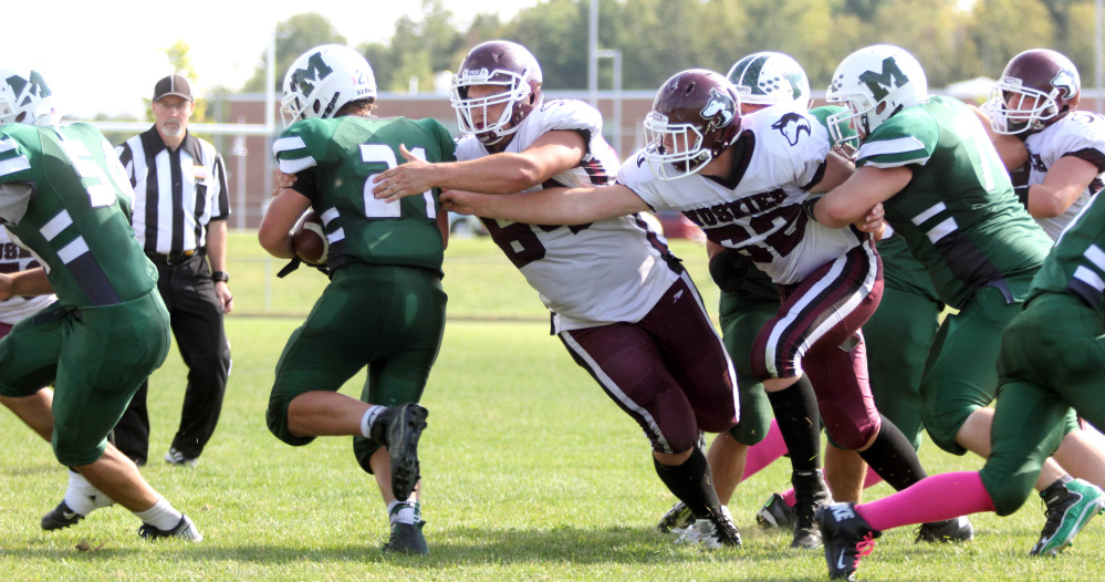 Photo by Jeff Pouland 
 Maine Central Institute's Curtis McLeod (64) and Mike Steeves (62) reach out to tackle Jack Axsom during the third quarter of last Saturday's game against Mount View High School in Thorndike.