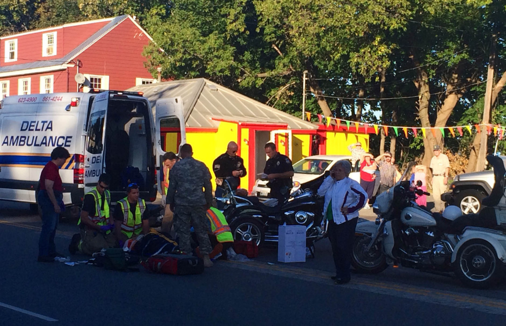 Emergency responders and onlookers gather around a two-motorcycle accident on College Avenue in Waterville Thursday evening. Diane and Michael Whalen, of Fairfield, were taken to the hospital after the three-wheeled motorcycle they were on rearended one driven by Glenn Whalen, Michael Whalen’s brother.