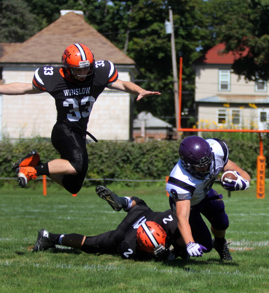 Photo by Jeff Pouland 
 Winslow High School's Ryan Fredette (33) helps Patrick Hopkins (2) in bringing down John Bapst's Spencer Baron during first-half action in Winslow earlier this season.