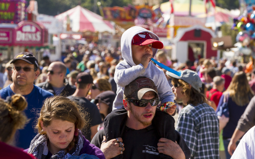 Ryon Harris, 3, gets an elevated view from atop his uncle Scott LeGrace’s shoulders Sunday at the Cumberland fair.