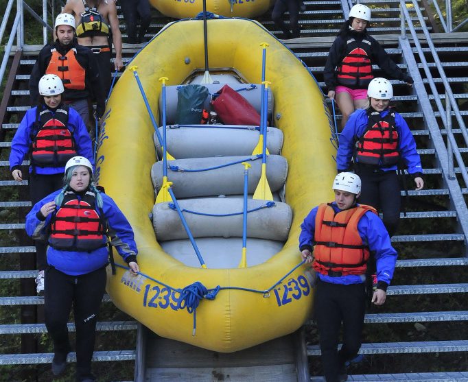 Whitewater rafters and guides with North Country Rivers in Bingham slide rafts down a rail system to launch the boats in the Kennebec River below the Harris Dam in West Forks on Saturday. Last weekend was popular for late season rafting because it was one of four times a turbine test was done that increased water volume from 4,800 cubic feet per second to 8,000. Tourism officials say that September is becoming more popular for tourists to the state and may soon eclipse June as the third best tourism month.