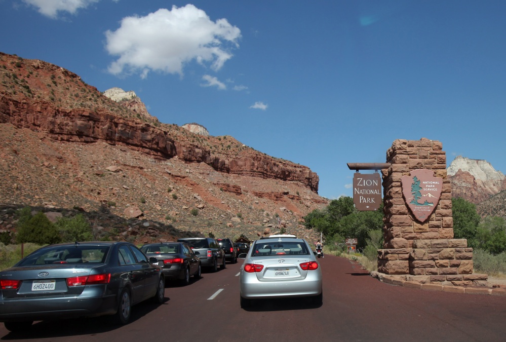Long lines of cars wait to enter the southern entrance to Zion National Park in Utah. The National Park Service already has recorded 5 million more visitors from this time last year, creating traffic congestion, long waits, and crowded parks.
