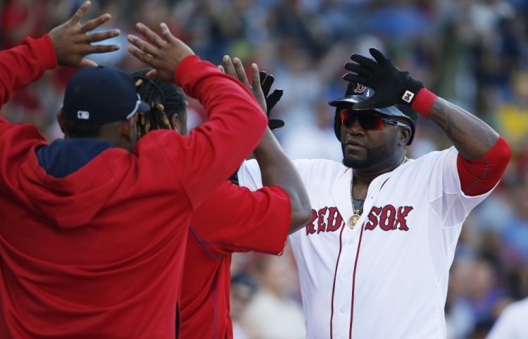 Boston Red Sox’s David Ortiz, right, celebrates his solo home run during the fourth inning of a baseball game against the Philadelphia Phillies in Boston, Saturday.