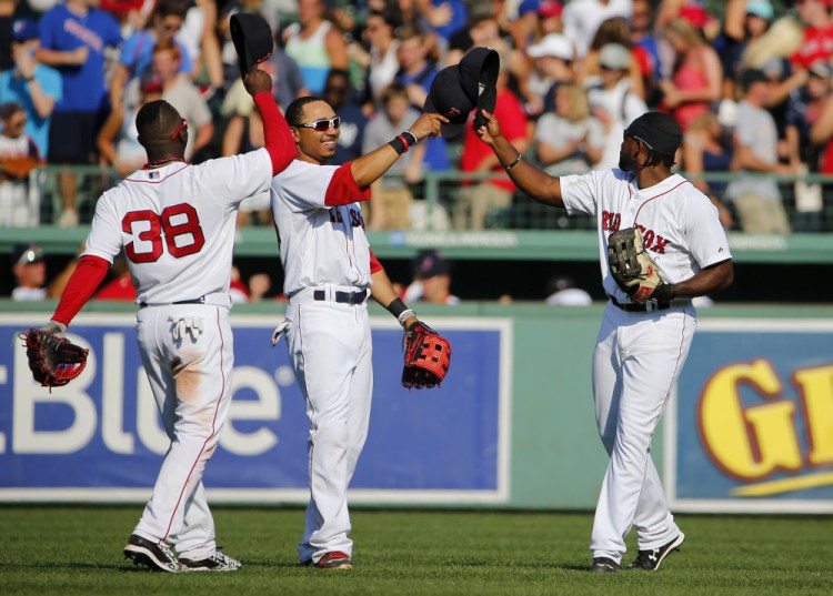 Red Sox outfielders, left to right, Rusney Castillo, Mookie Betts and Jackie Bradley Jr. celebrate after Boston’s 11 win over the Toronto Blue Jays on Monday at Fenway Park.