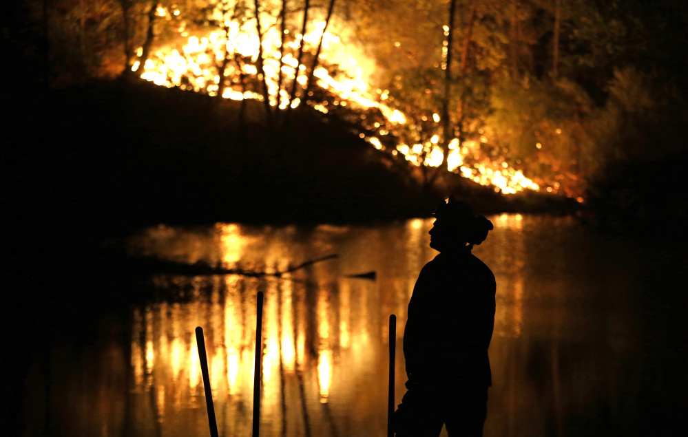 A firefighter stands near a wildfire in Middletown, Calif., on Sunday. Two of California’s fastest-burning wildfires in decades overtook several Northern California towns.