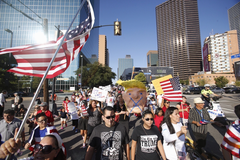 A group marches outside the arena where Republican presidential candidate Donald Trump was holding a campaign event in Dallas on Monday. A conservative group says it will spend up to $1 million on anti-Trump ads.
