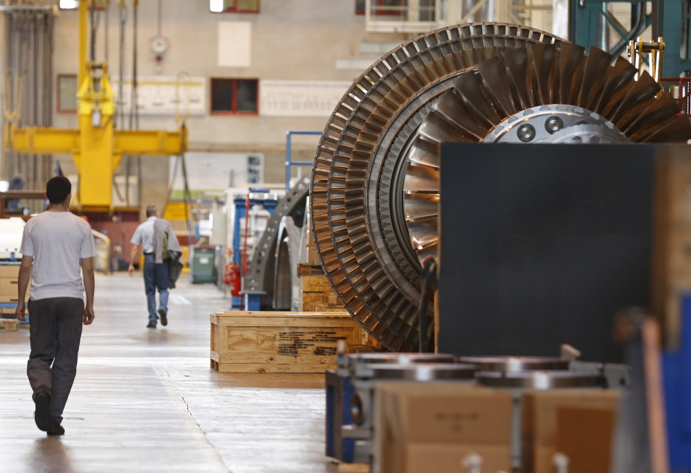 A worker walks past a gas turbine under construction at the gas turbines production unit of the General Electric plant in Belfort, France.
