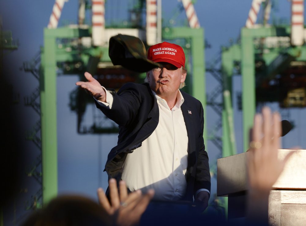 Republican presidential candidate Donald Trump throws a baseball cap from the stage after speaking to supporters at campaign event aboard the USS Iowa battleship in Los Angeles Tuesday.
