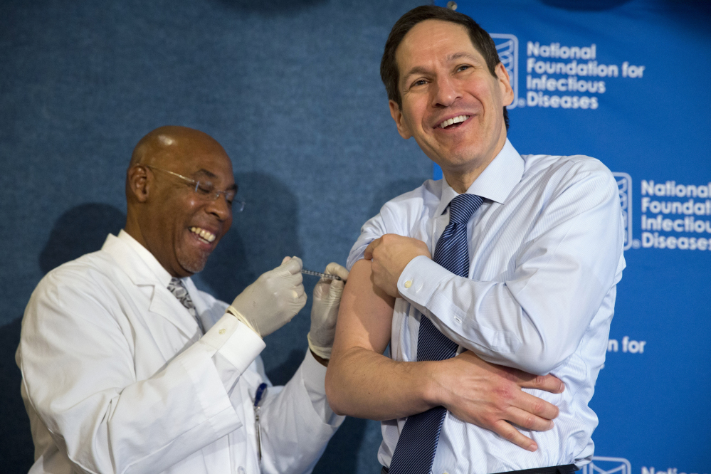 Centers for Disease Control and Prevention Director Dr. Tom Frieden laughs as he receives a flu shot from nurse B.K. Morris during an event about flu vaccinations Thursday at the National Press Club in Washington.