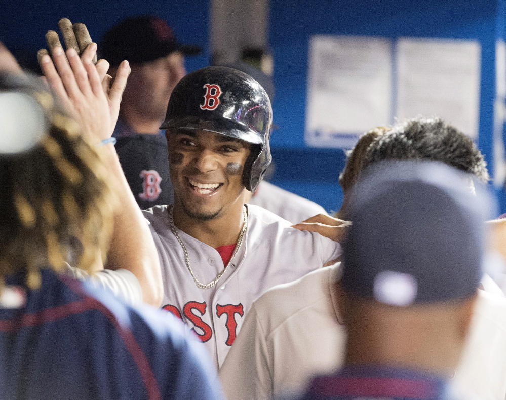 Red Sox shortstop Xander Bogaerts celebrates with teammates after hitting a home run in the sixth inning Saturday against the Toronto Blue Jays. The Red Sox won, 7-6.