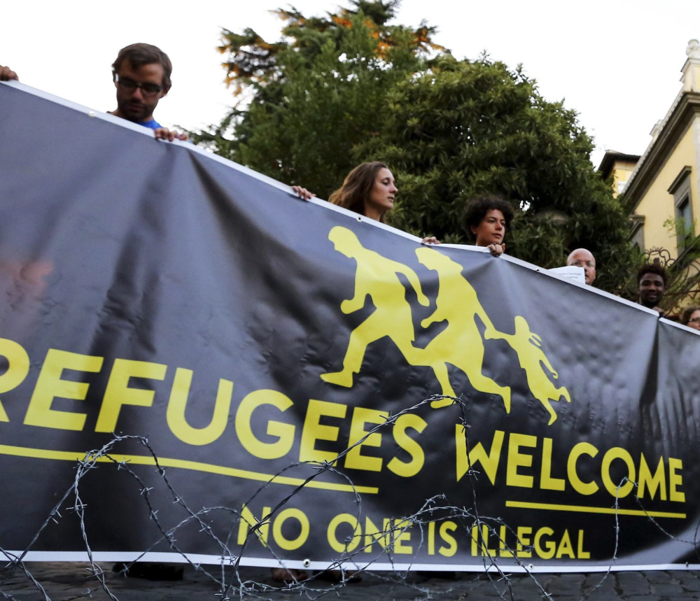 Activists hold a banner in front of the Hungarian Embassy in Rome. Hungary, Romania, the Czech Republic and Slovakia voted against spreading asylum-seekers across Europe.