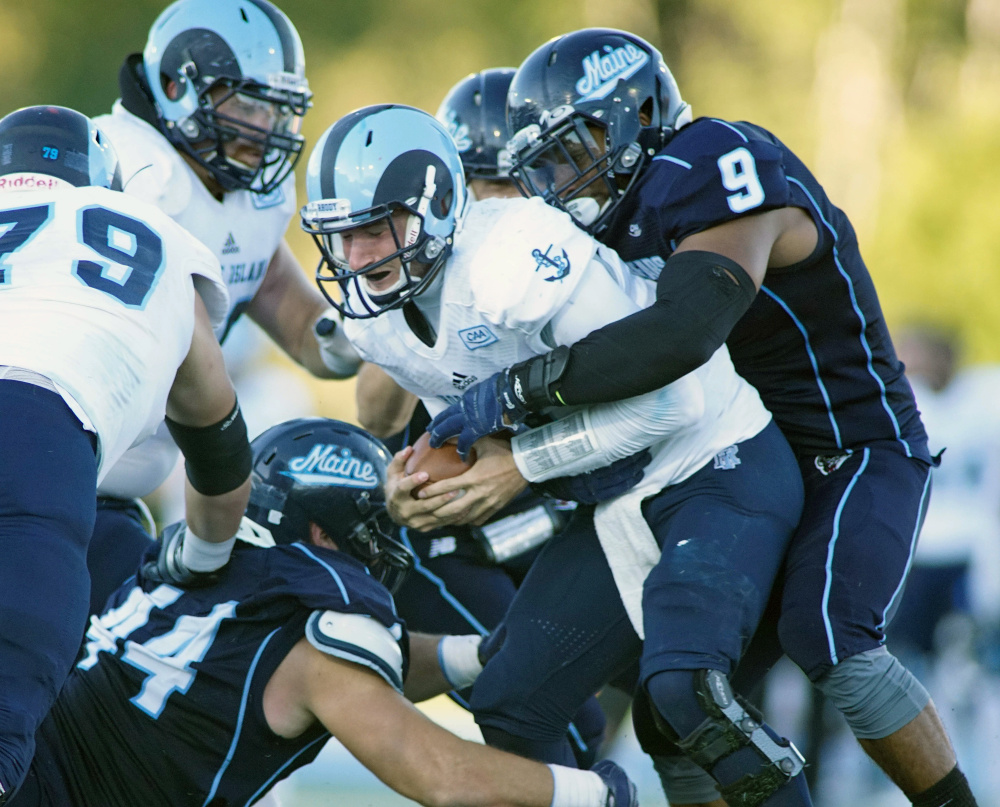 Rhode Island quarterback Paul Mroz feels the pressure from Maine’s Trevor Bates, right, and other defenders during the Black Bears’ 27-17 win over the Rams on Saturday in Orono.