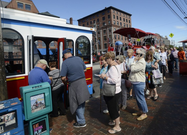 A line forms for the trolley Monday on Commercial Street in Portland. Busier Septembers have changed the operations of businesses that used to shut down right after Labor Day.