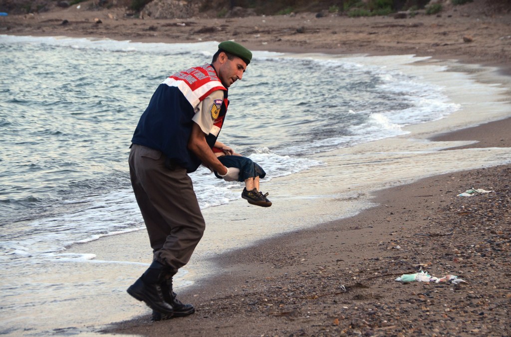 A paramilitary police officer carries the lifeless body of Aylan Kurdi, 3, after a number of migrants died and a smaller number were reported missing after boats carrying them to the Greek island of Kos capsized, near the Turkish resort of Bodrum early Sept. 2. The Associated Press