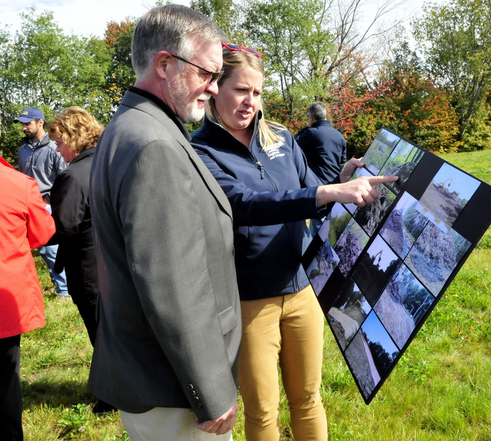 Jamie Madore of Ransom Consultants shows photos of the former Wilton Tannery waste site that is now contained at the site in Wilton on Thursday. Looking on is Dave Mitchell.