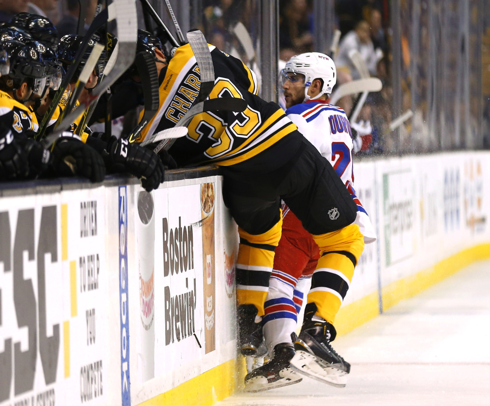 Boston Bruins defenseman Zdeno Chara is checked into the boards by New York Rangers’ Ryan Bourque during the first period of a preseason game last month in Boston. Chara was injured on the play and left the game.
