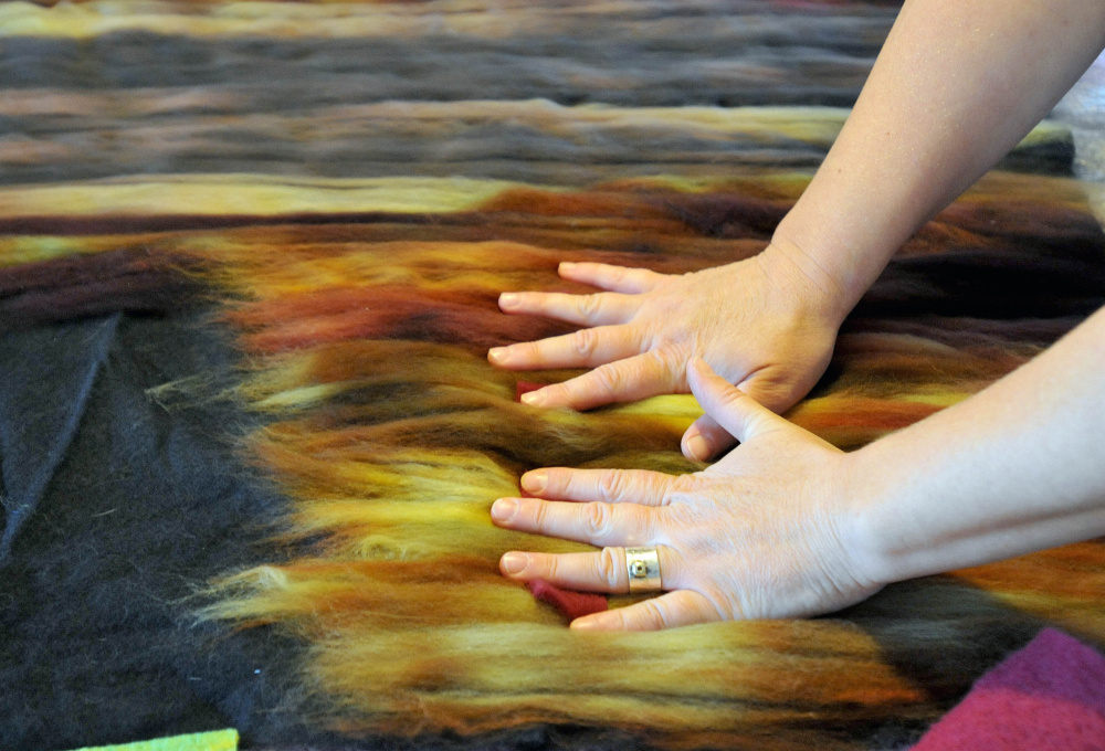 Heather Kerner makes a large felt tapestry that will be cut down to smaller felt designs Saturday during an art demonstration in her kitchen at her Pinnacle Road residence in Canaan as part of the Wesserunsett Arts Council’s sixth annual open studio tour.