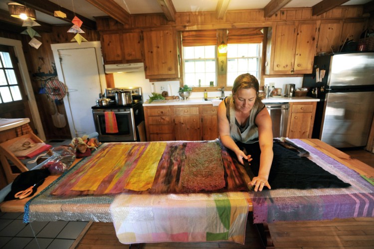Heather Kerner demonstrates how she creates felt designs Saturday on her kitchen table at her family’s Pinnacle Road residence in Canaan during the Wesserunsett Arts Council’s sixth annual open studio tour.