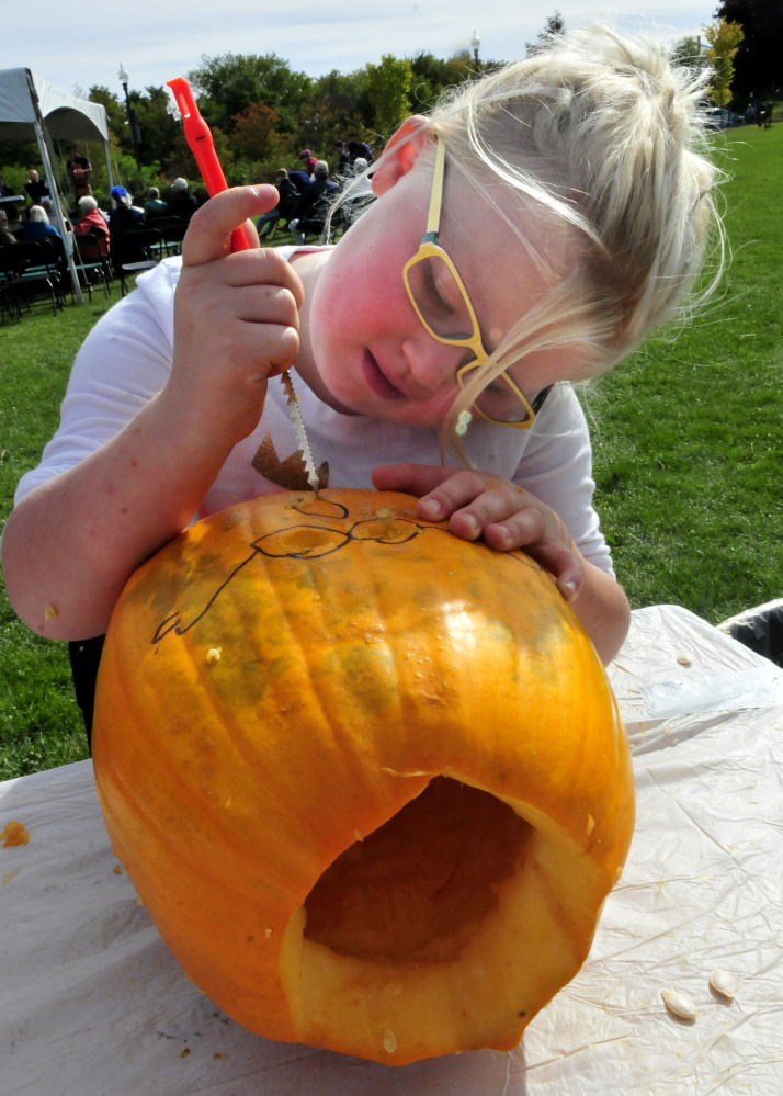 Payten Frederick uses a safety knife to carve a pumpkin Sunday during the Harvest Fest and Festival of the Falls event in Waterville.