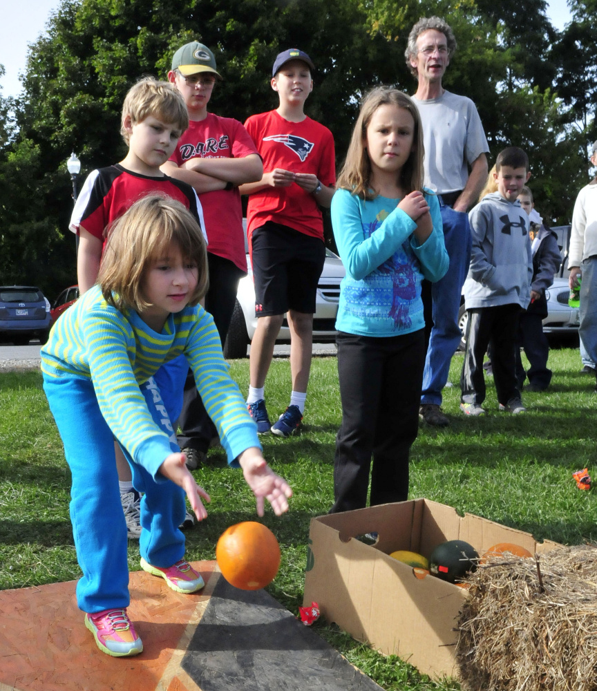Abigail Taylor bowls a pumpkin Sunday during an event of the Harvest Fest and Festival of the Falls in Waterville.