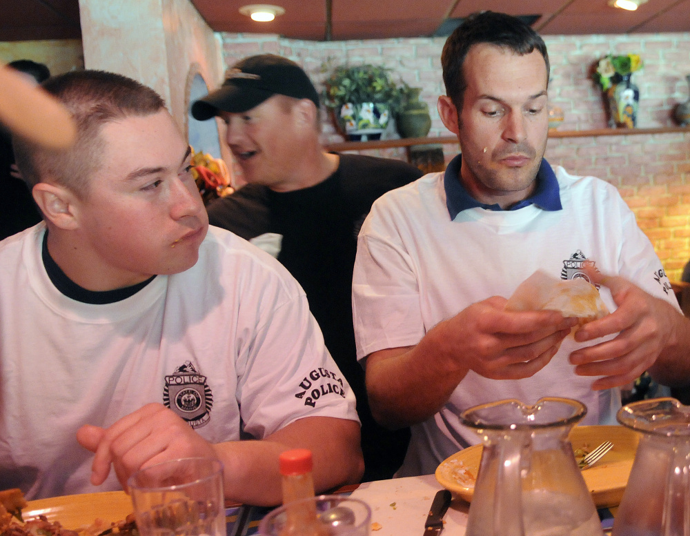 The Augusta Police Department’s animal control officer, Francois Roodman, right, wipes his hands Sunday after winning a taco eating contest between the Waterville and Augusta police.