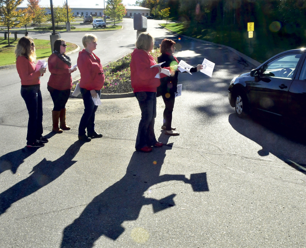 OAKLAND,ME.-October 6: Communications Workers of America attempt to hand out flyers to T-Mobile company employees entering the company in Oakland on Tuesday, October 6, 2015. A news conference was held later regarding former employee Angela Agganis and her treatment by the company regarding a sexual harassment complaint she made.  (Photo by David Leaming/Staff Photographer)