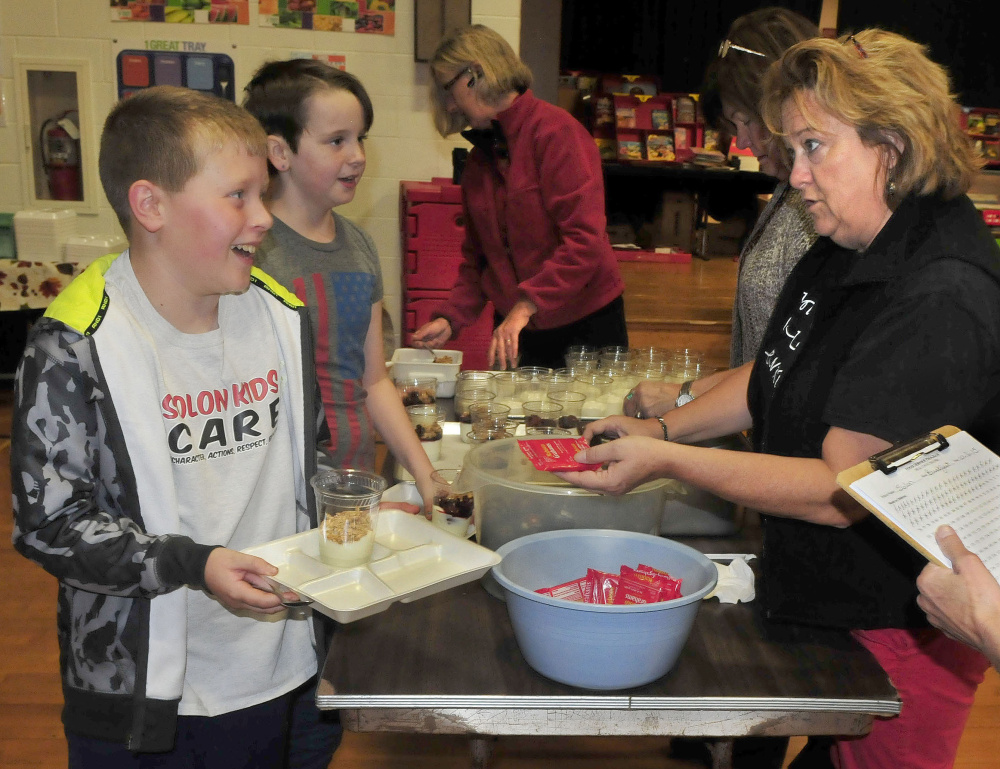 Solon Elementary School student Hunter Sousa accepts a snack from teacher Michelle Stevens after students took part in the Walking School Bus Tuesday. Asked what he thought of the walk Sousa said, ”It’s fun and I like hanging out with my friends.”
