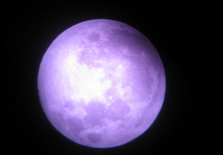 The Earth’s shadow inches onto the edge of the moon the evening of Sept. 27, as seen from the Troy woods.