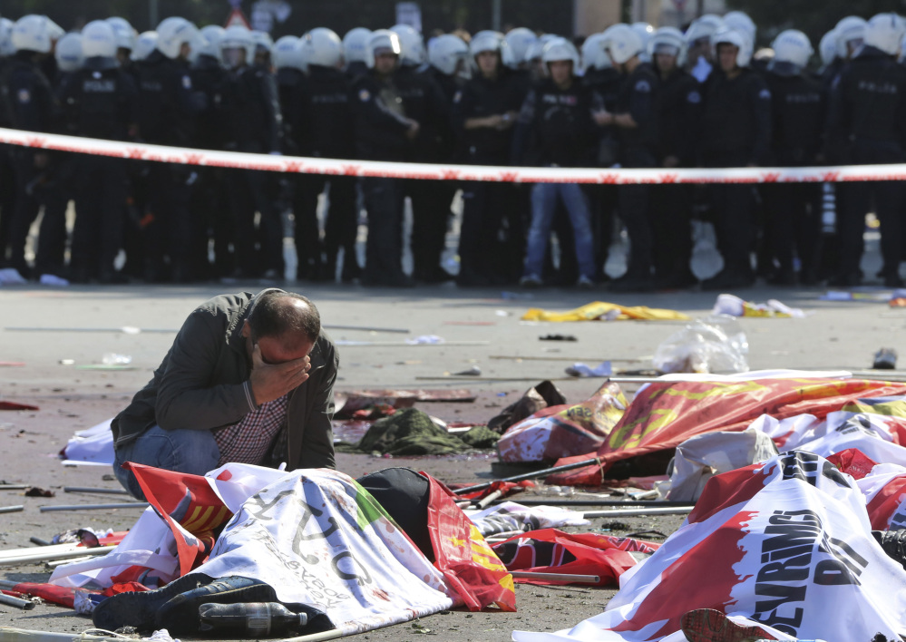 A man cries over the body of a victim, at the site of an explosion in Ankara, Turkey, Saturday.