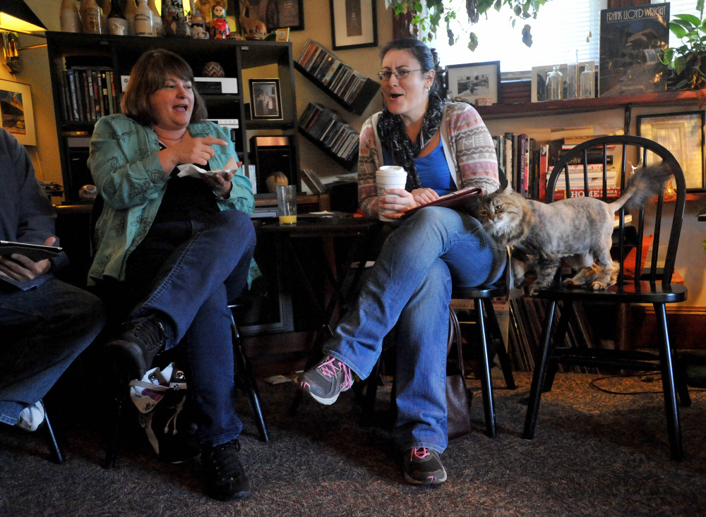 May, a Maine coon cat, cuddles up with Anna Holderman on Saturday during a South End Neighborhood Association meeting at the home of Chris Moody on Summer Street in Waterville. The meeting was about providing health care services for pets of low-income residents in the city.